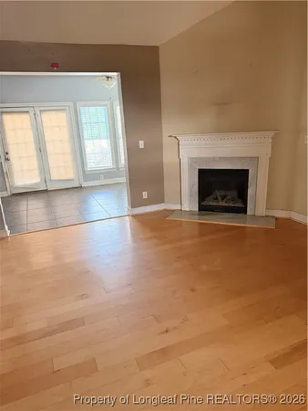 a view of an empty room with window and fireplace