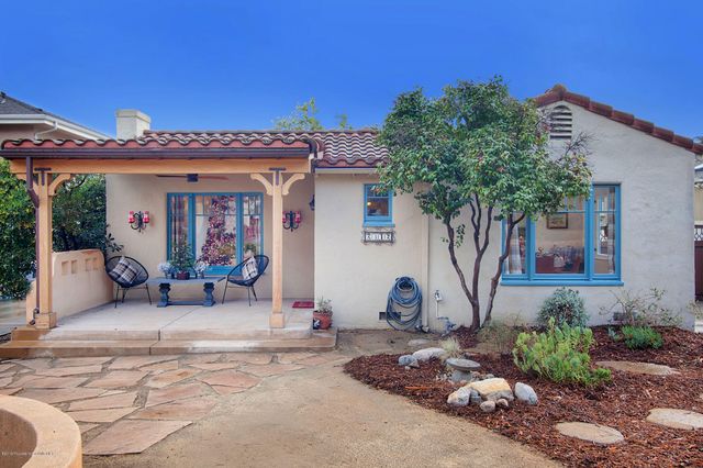 a view of a house with backyard and sitting area