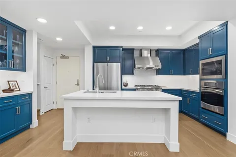 a large kitchen with stainless steel appliances granite countertop a stove refrigerator and a sink