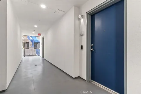 a view of a hallway with stainless steel appliances