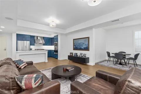 a living room with furniture and a dining table with kitchen view