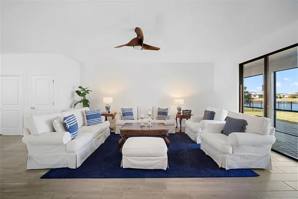 a living room with furniture kitchen view and a large window