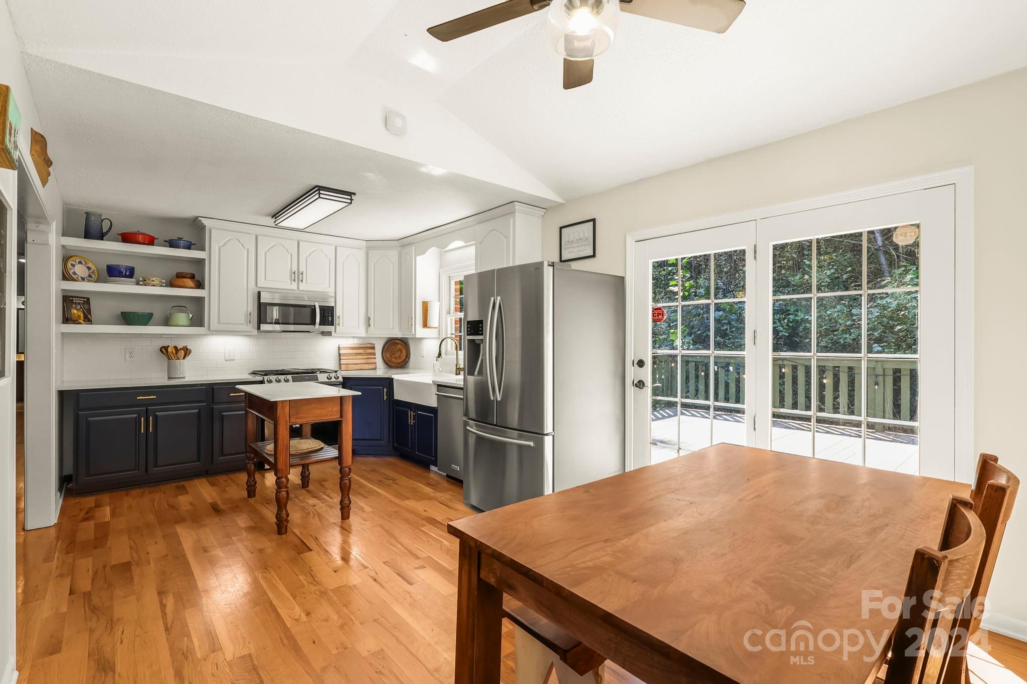 3409 Collettsville Road Lenoir, NC 28645 - Photo 13 of 48 a kitchen with stainless steel appliances granite countertop a stove a refrigerator a sink a dining table and chairs with wooden floor
