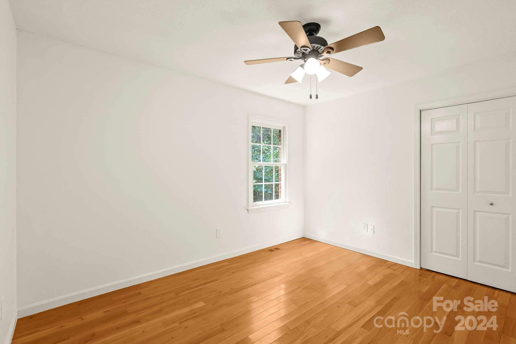 3409 Collettsville Road Lenoir, NC 28645 - Photo 19 of 48 an empty room with wooden floor and ceiling fan