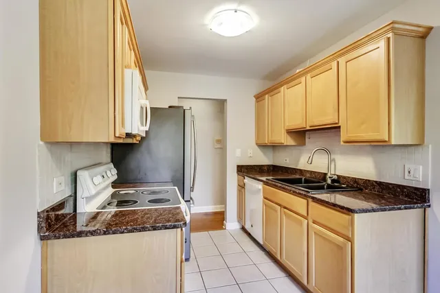 a kitchen with stainless steel appliances granite countertop a stove a sink and a refrigerator