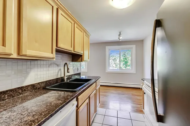 a kitchen with granite countertop a sink a stove and cabinets