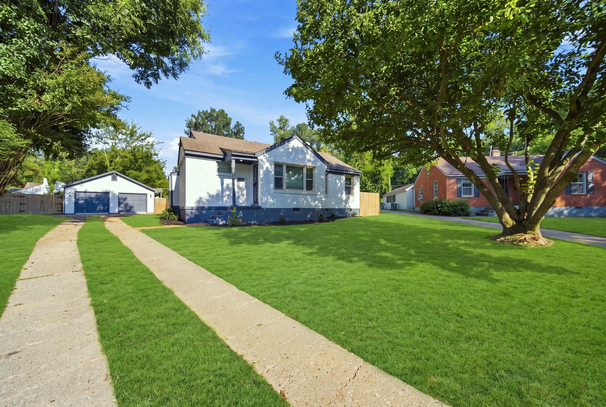 458 Gerald Road Memphis, TN 38122 - Photo 1 of 37 Expansive front lawn with mature trees and a concrete driveway