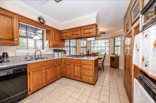 a large kitchen with stainless steel appliances granite countertop a sink and cabinets