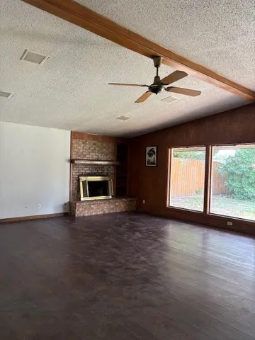 a view of empty room with fireplace and fan