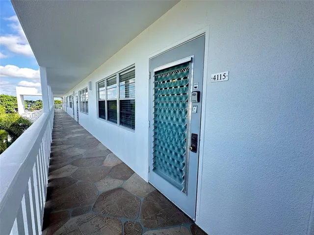 a hallway with wooden floor and windows