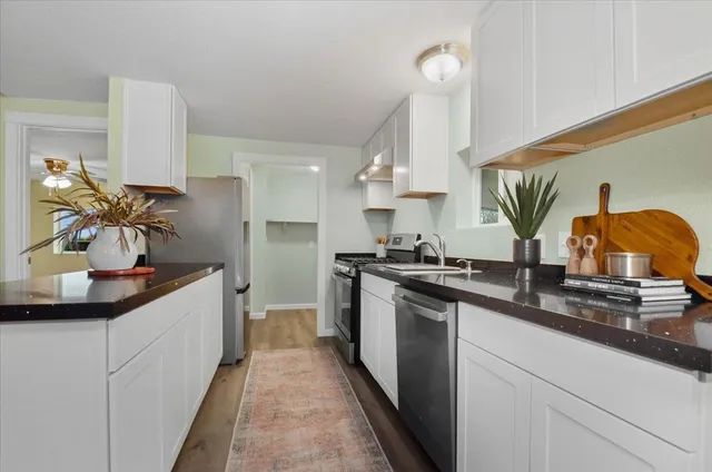 a kitchen with kitchen island granite countertop a sink stainless steel appliances and cabinets