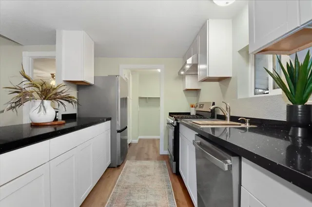 a kitchen with a sink a stove and cabinets
