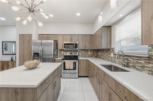 a kitchen with stainless steel appliances kitchen island granite countertop a sink a stove a refrigerator cabinets and chairs