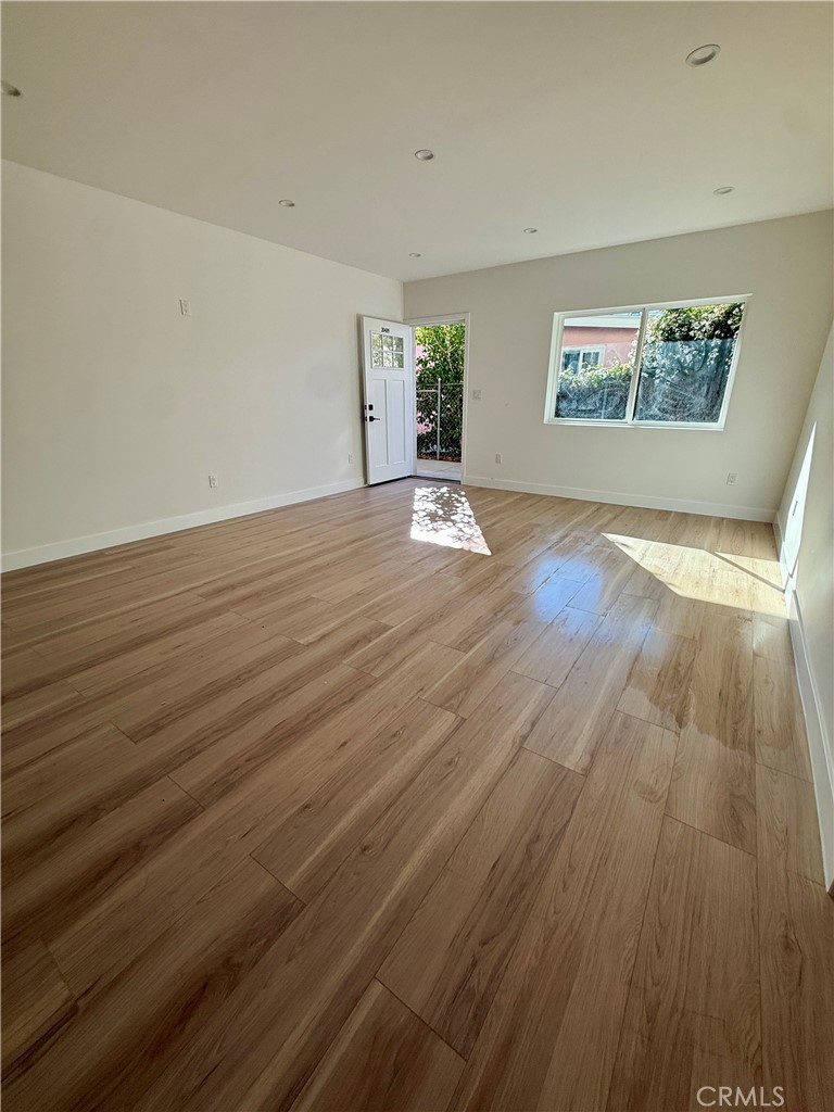 20407 Strathern Street, Unit 20409 Winnetka, CA 91306 - Photo 3 of 8 wooden floor in an empty room with a window