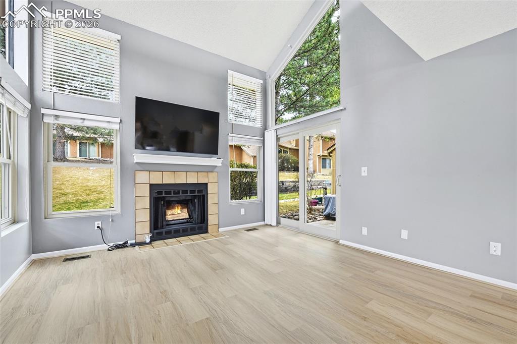 365 Autumn Ridge Circle, Unit A Colorado Springs, CO 80906 - Photo 5 of 30 The vaulted living room features a walk-out patio & cozy wood-burning fireplace with mounted TV, creating the perfect space to relax or entertain.