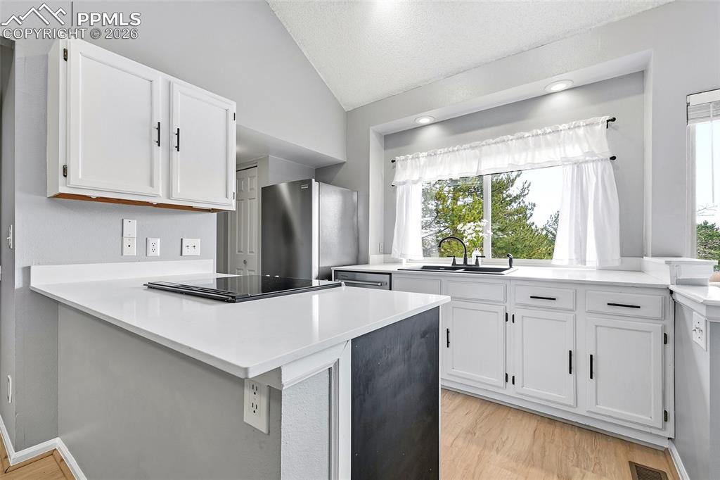 365 Autumn Ridge Circle, Unit A Colorado Springs, CO 80906 - Photo 9 of 30 The galley kitchen is both functional and stylish, offering quartz countertops, a large picture window showcasing beautiful sunrise views...