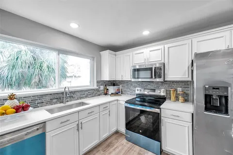 a kitchen with a sink stove top oven and refrigerator