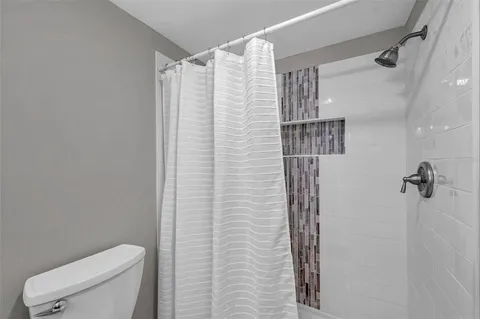 a bathroom with a shower and toilet