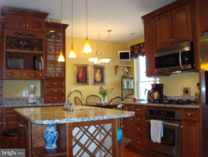 721 Runabout Loop, Unit 721 Solomons, MD 20688 - Photo 4 of 23 a kitchen with stainless steel appliances granite countertop a sink stove and cabinets