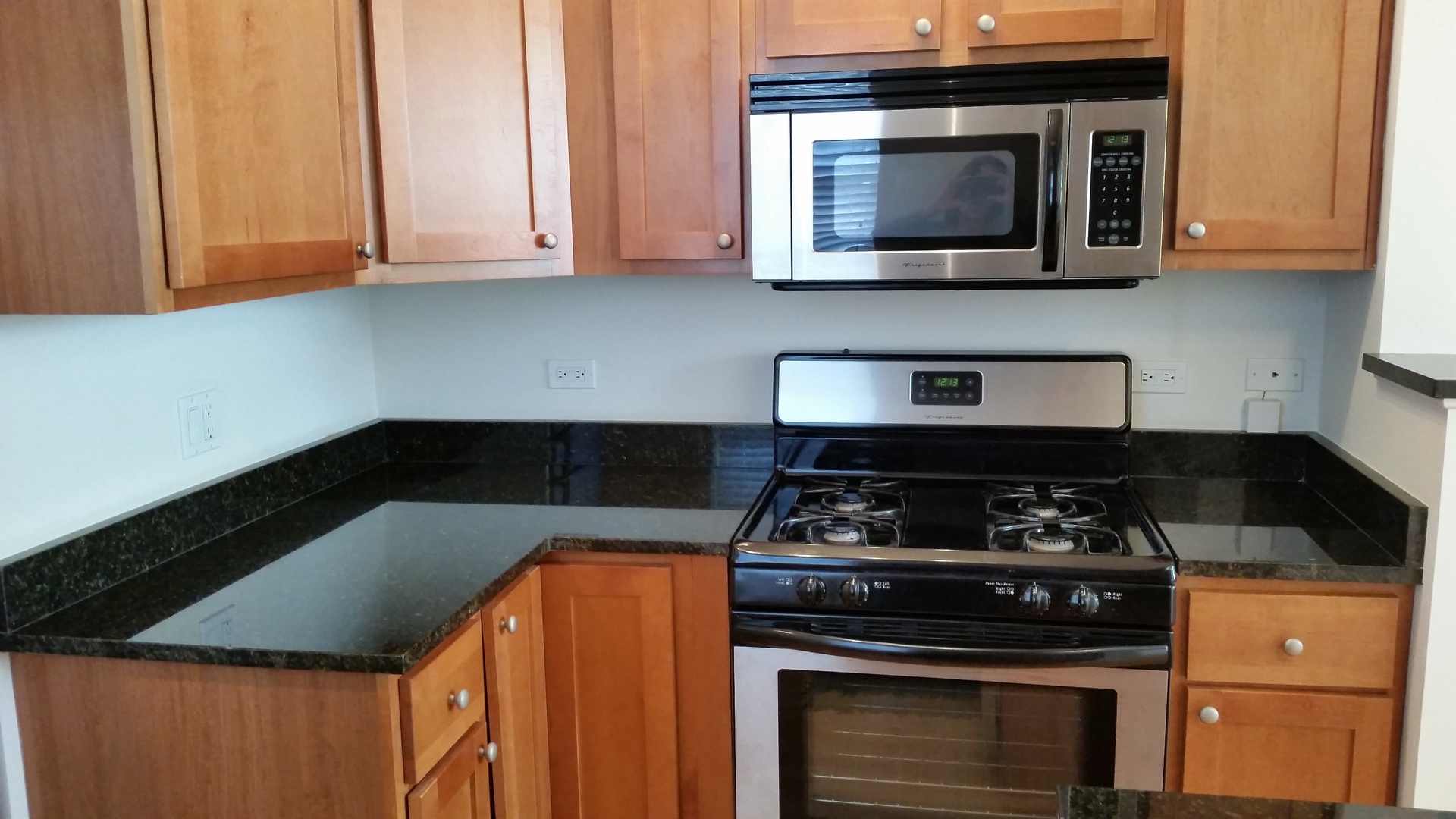 58 Forest Avenue, Unit G Riverside, IL 60546 - Photo 8 of 19 a kitchen with granite countertop cabinets stove top oven and microwave