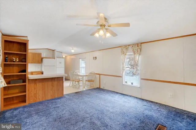 a view of a kitchen with furniture and a ceiling fan