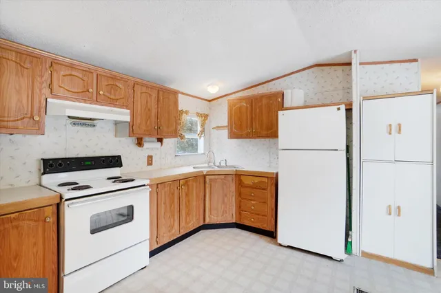 a kitchen with white cabinets and white appliances