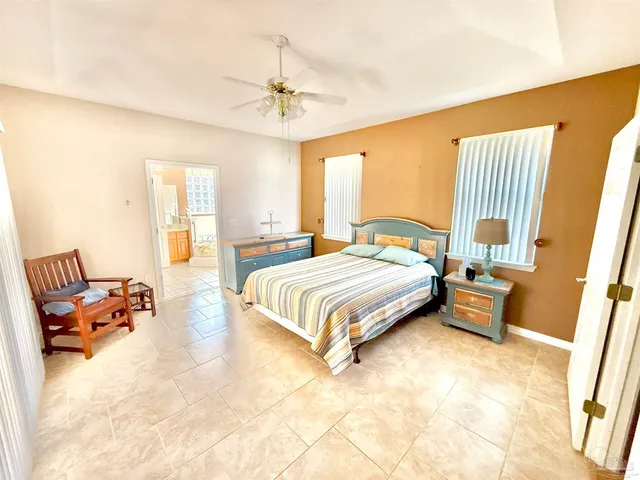 an empty room with a chandelier fan and windows