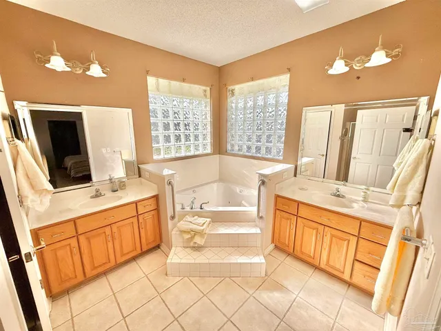 a bathroom with a tub sink and mirror