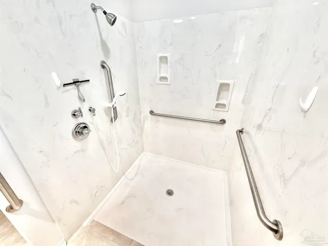 a view of a brick house with a small yard and a large tree