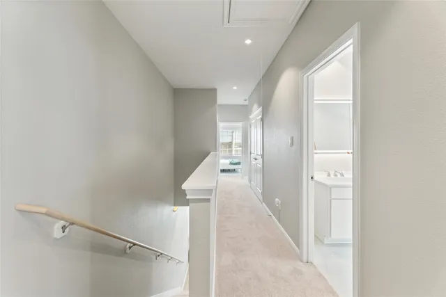 a hallway with a white walls and stairs