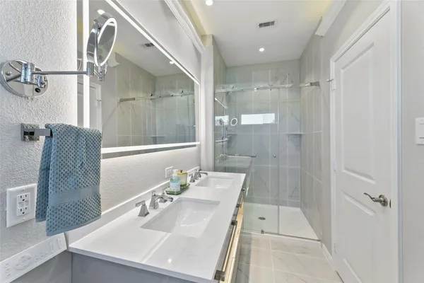 a bathroom with a sink shower and a mirror