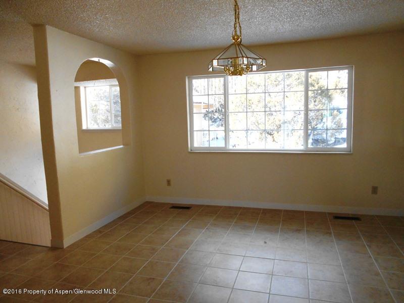10874 Highway 13 Rifle, CO 81650 - Photo 11 of 15 an empty room with windows and chandelier