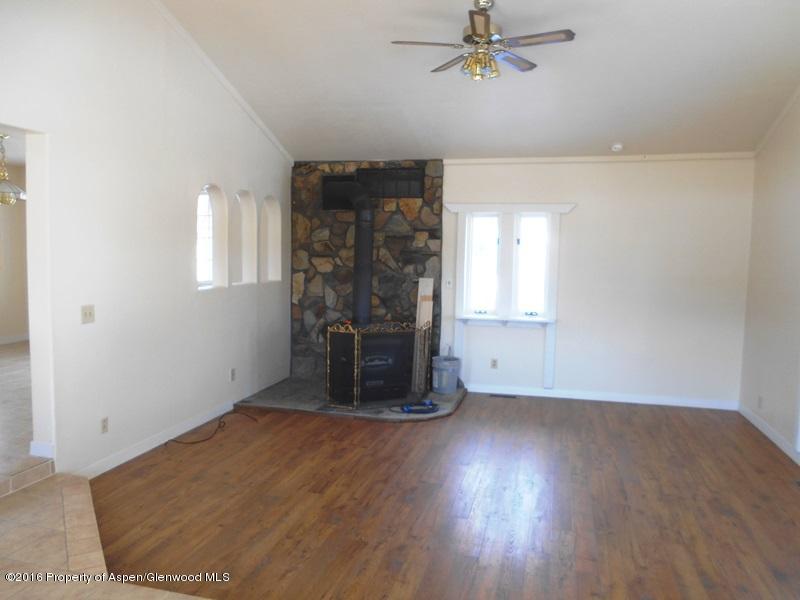 10874 Highway 13 Rifle, CO 81650 - Photo 8 of 15 an empty room with wooden floor and windows