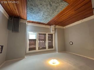 62-53 80th Road Queens, NY 11385 - Photo 8 of 11 Empty room with radiator, ornamental molding, and dark wood-type flooring
