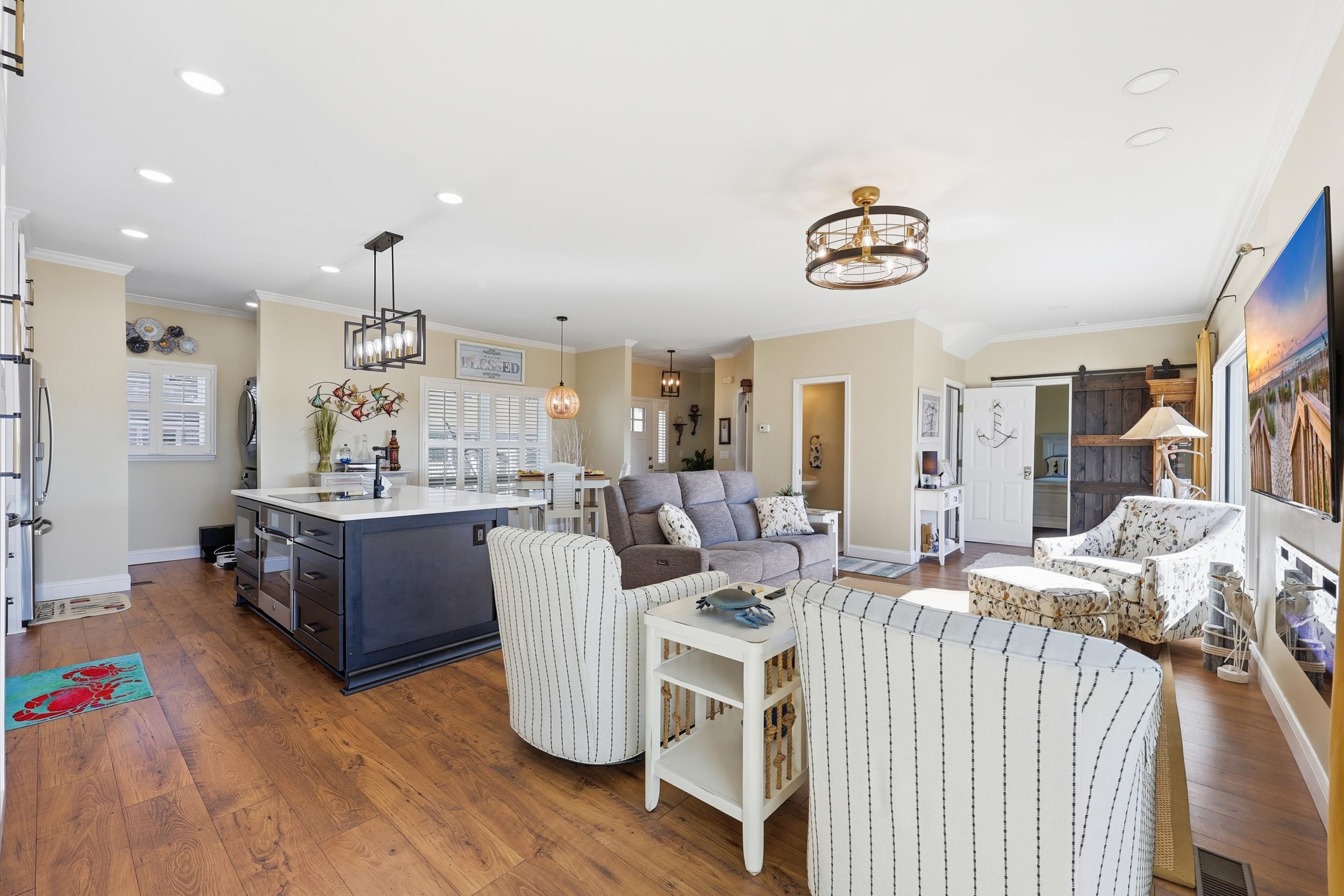 4524 Landing Road Little River, SC 29566 - Photo 11 of 40 Living area featuring a barn door, a chandelier, ornamental molding, dark wood-style floors, and recessed lighting