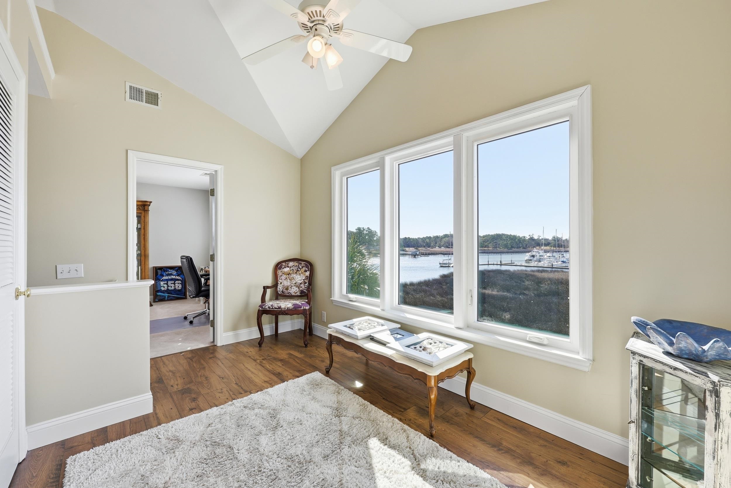 4524 Landing Road Little River, SC 29566 - Photo 19 of 40 Living area with a water view, vaulted ceiling, dark wood finished floors, a ceiling fan, and an office area