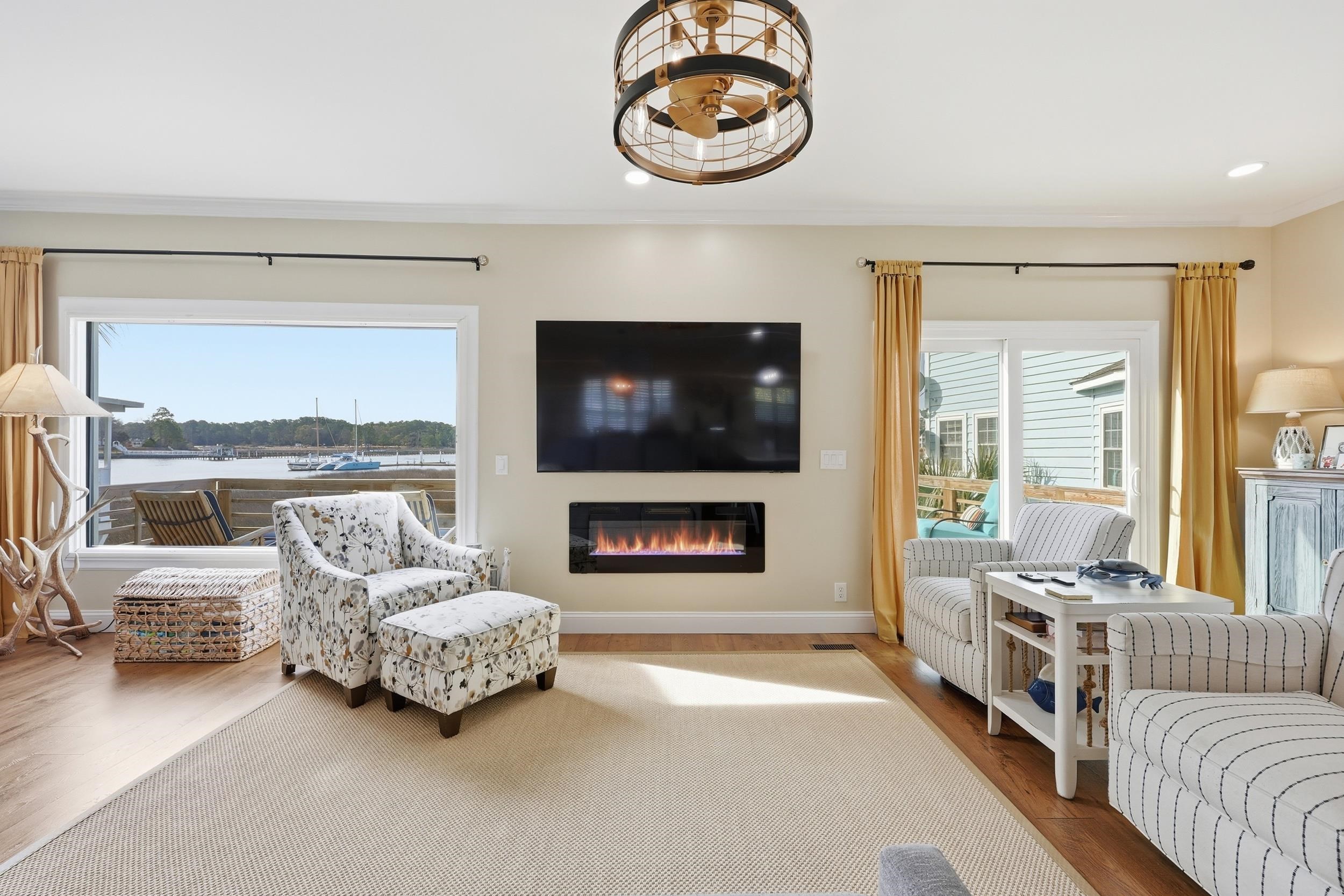 4524 Landing Road Little River, SC 29566 - Photo 5 of 40 Living area with wood finished floors, a glass covered fireplace, healthy amount of natural light, ornamental molding, and recessed lighting
