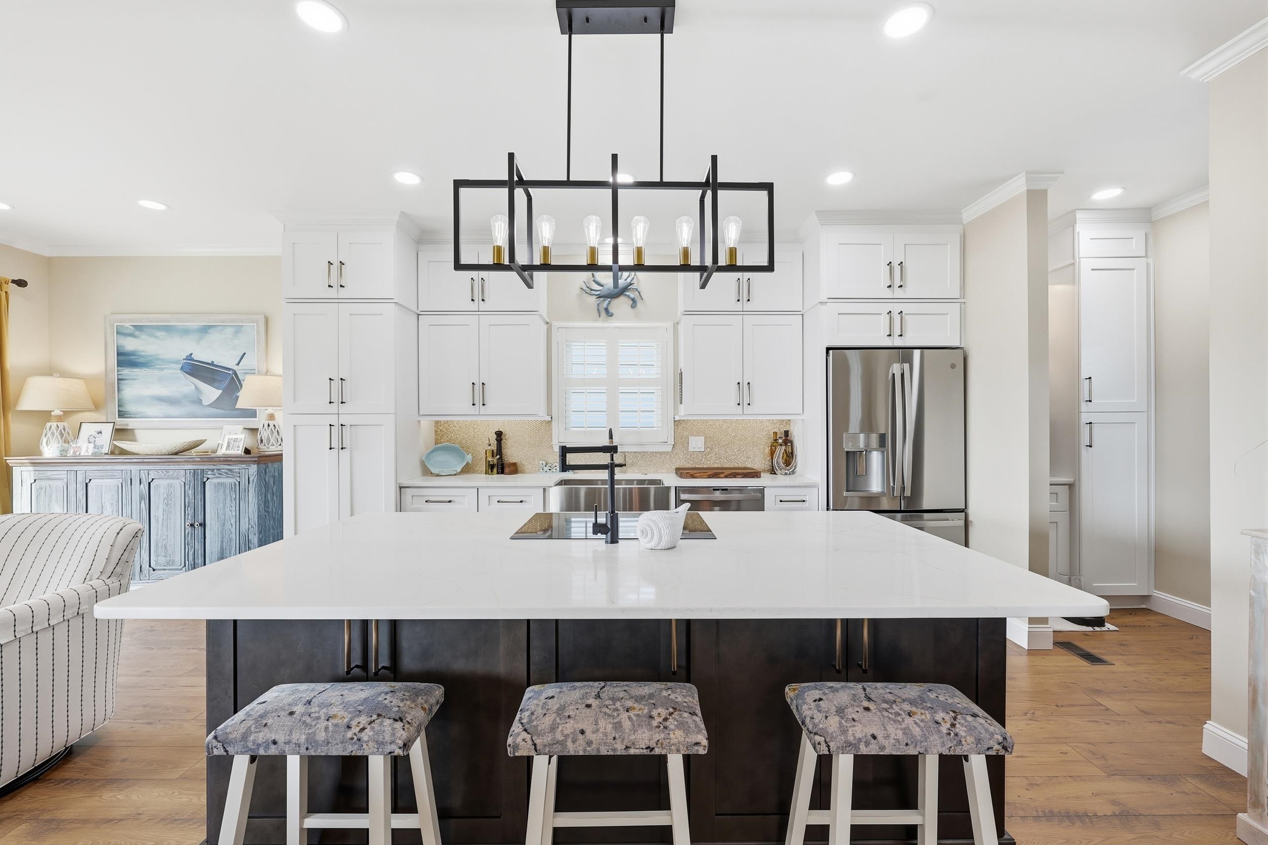 4524 Landing Road Little River, SC 29566 - Photo 6 of 40 Kitchen with white cabinets, a kitchen bar, a kitchen island with sink, ornamental molding, and pendant lighting
