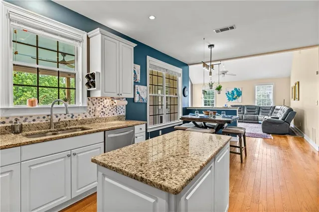 a kitchen with stainless steel appliances granite countertop a refrigerator sink and microwave