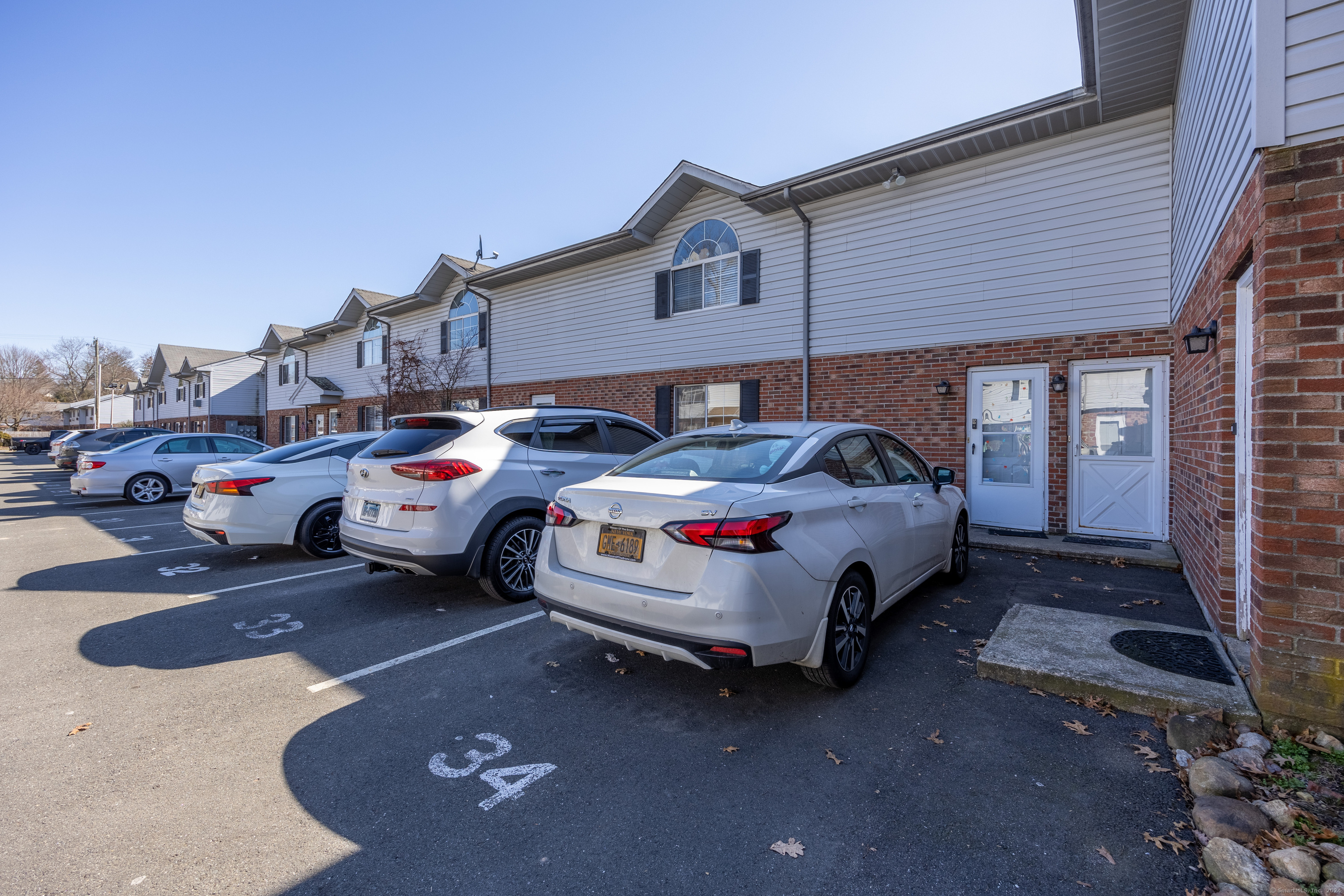 a front view of a house with cars parked