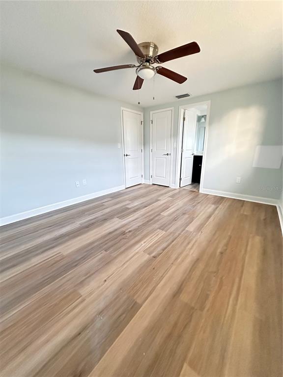 4407 Summersun Drive New Port Richey, FL 34652 - Photo 18 of 34 a view of an empty room with wooden floor and a ceiling fan