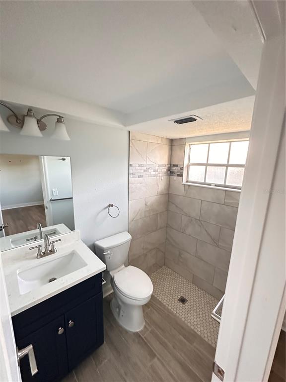 4407 Summersun Drive New Port Richey, FL 34652 - Photo 20 of 34 a bathroom with a sink mirror toilet and shower