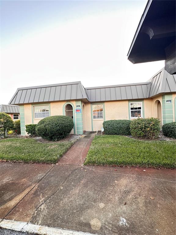 4407 Summersun Drive New Port Richey, FL 34652 - Photo 2 of 34 a front view of a house with a yard and garage