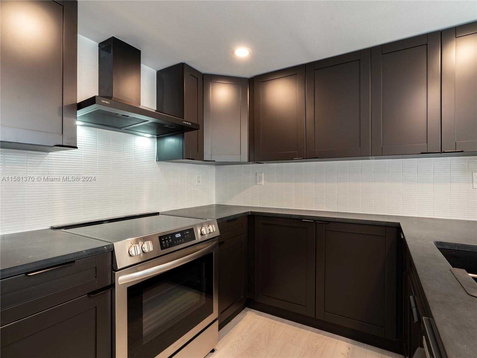 a kitchen with stainless steel appliances wooden cabinets and stove top oven