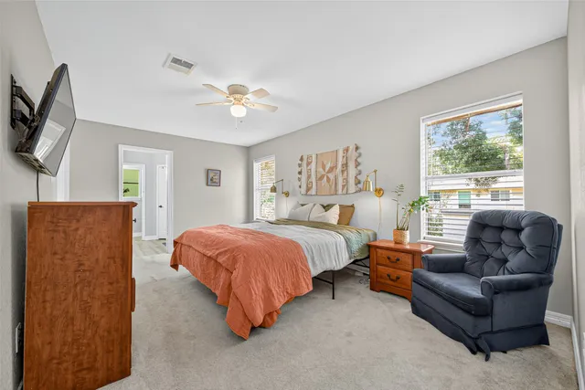 a spacious bedroom with a bed couch and window