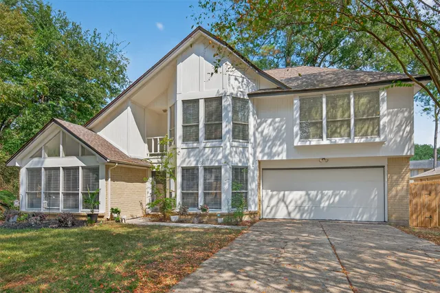 a front view of a house with a garden and trees