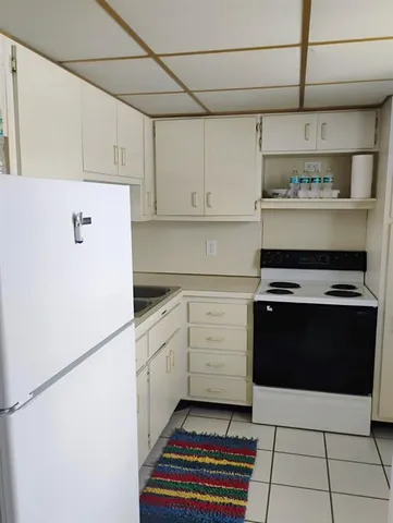 a kitchen with a stove and white cabinets