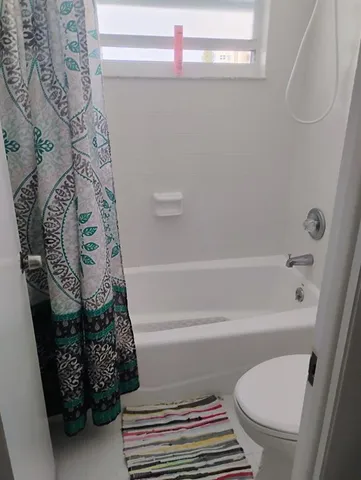 a bathroom with a toilet and a shower curtain