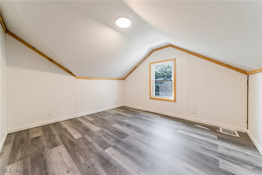 33384 Chestnut Ridge Road North Ridgeville, OH 44039 - Photo 19 of 30 Additional living space featuring light wood-type flooring, lofted ceiling, and wooden walls