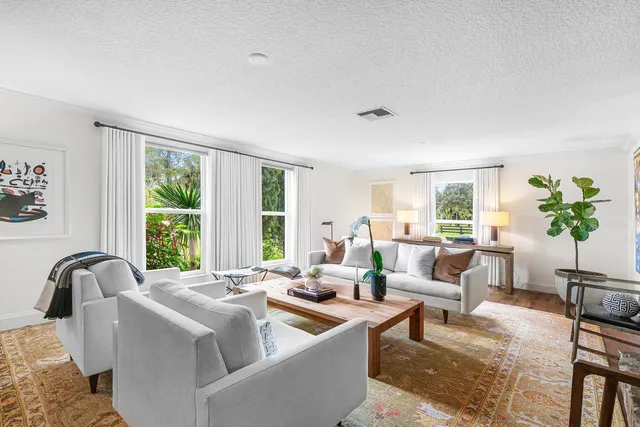 a living room with furniture a flat screen tv and a window